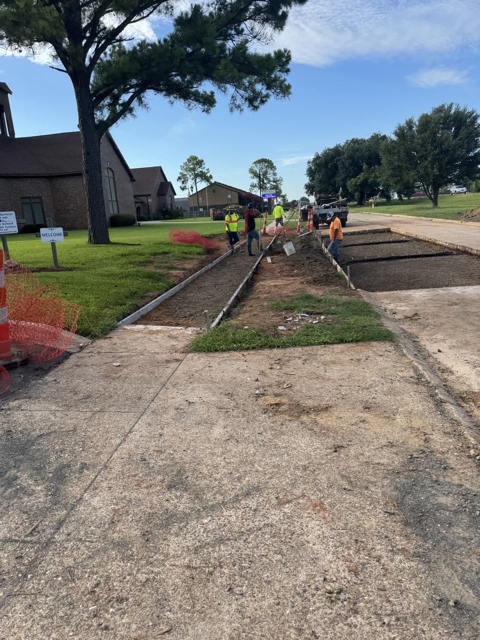 Silverback crew setting forms and preparing subgrade for a new concrete sidewalk and driveway approach along a church campus frontage